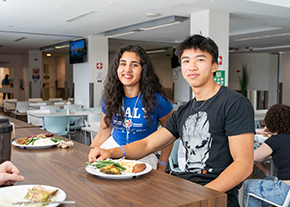 Two students eating in the dining hall.
